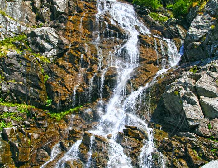 Summer Waterfall In A Rocky Mountain