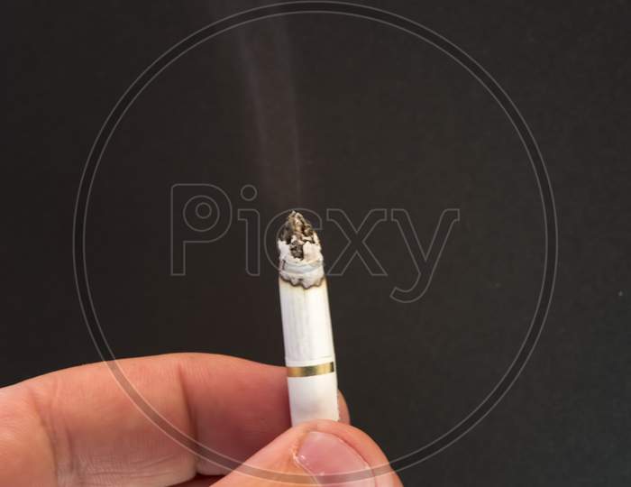 Burning Cigarette On Dark Background