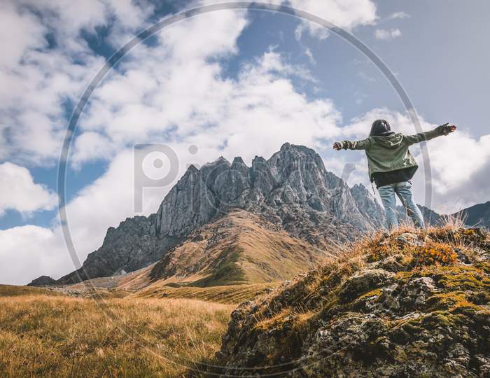 Back Side Of Female Woman With Spreaded Hand Out Of Joy Looking To Beautiful Mountains Landscape