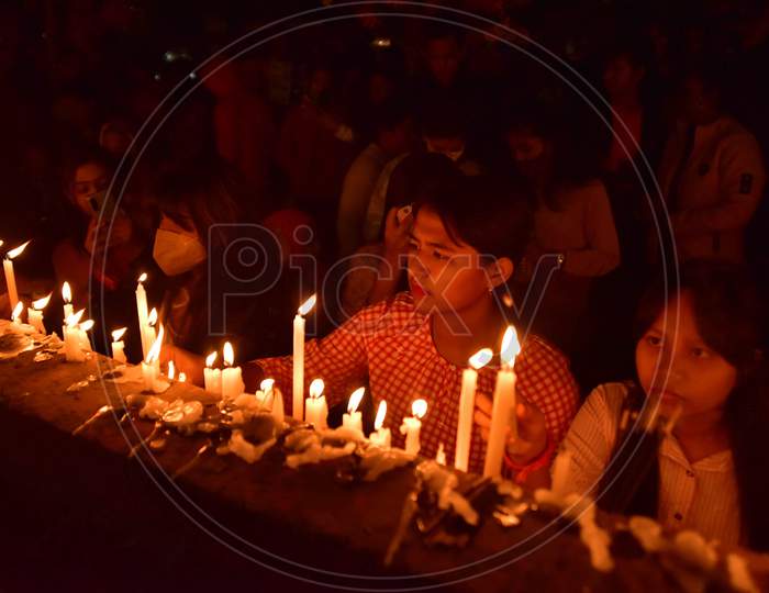 Devotees light candle at a church on the occasion of Christmas in Nagaon district, in the northeastern state of Assam, India, December 25,2020