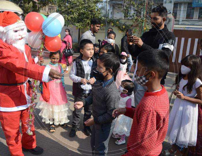 A Man Dressed As Santa Claus Distributes Sweets And Balloons Among The Children On The Occasion Of Christmas At St. Joseph Chruch, Panbazar In Guwahati On Friday, December 25, 2020.