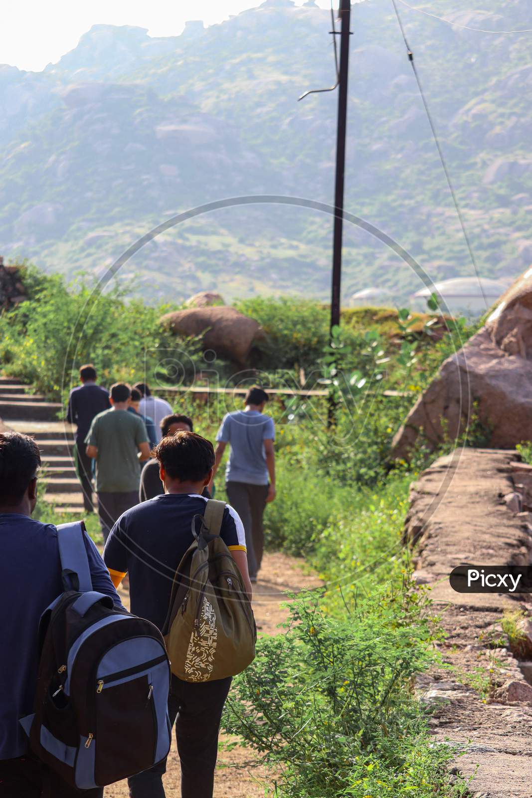 Ider, India - September 27 2020 : Young Asian traveling backpacker on the way of mountain with his friends.