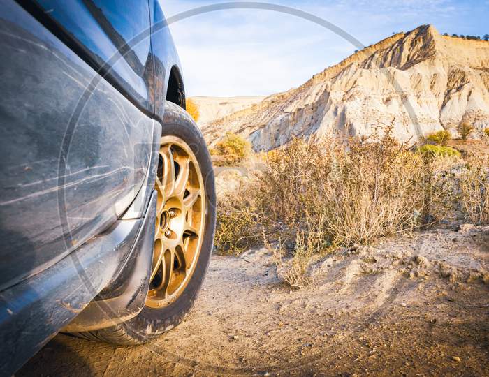 Close Up Right 4Wd Wheel With Sandy Terrain And Rocky Landscape. Off Road Travel In Caucasus Concept