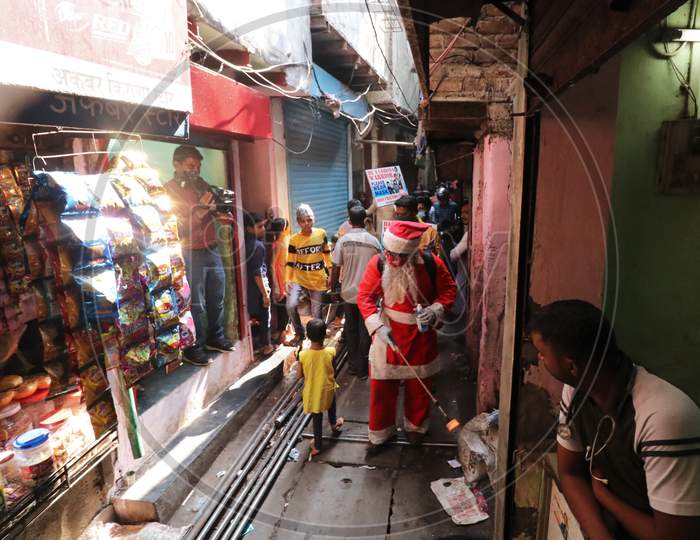 A man wearing a Santa Claus costume sanitizes a slum area, amidst the spread of the coronavirus disease (COVID-19), in Mumbai, India, December, 2020.