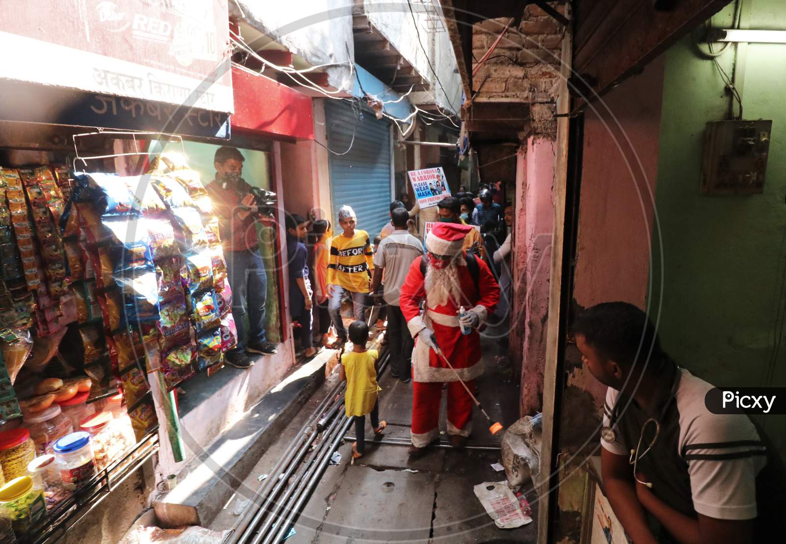 A man wearing a Santa Claus costume sanitizes a slum area, amidst the spread of the coronavirus disease (COVID-19), in Mumbai, India, December, 2020.
