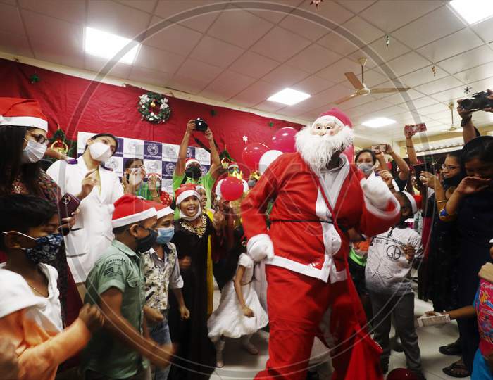 A man dressed as Santa Claus dances with patients during Christmas celebration, at Wadia Hospital For Children in Mumbai, India on December, 2020.