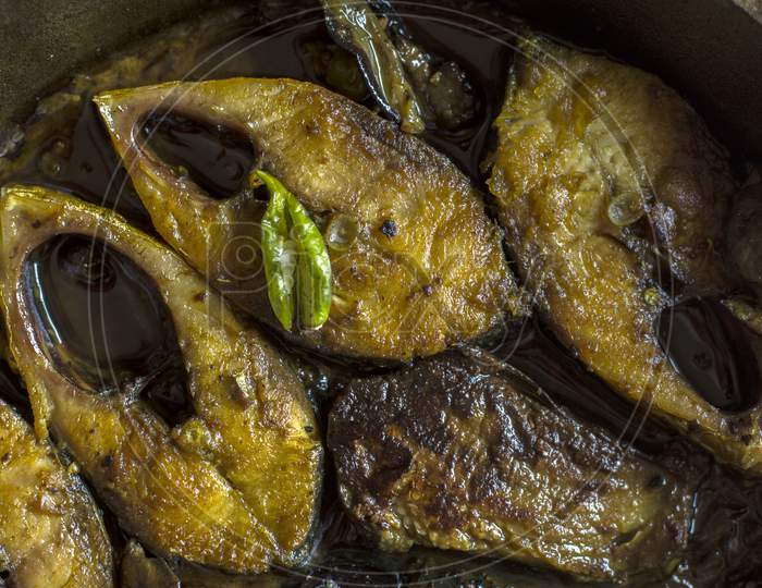 Slices Of Tenualosa Ilisha Or Hilsha Fish On A Black Wooden Background