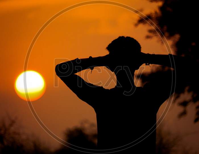 Kheralu, Gujarat - November 19, 2020 : Black silhouette of man, man is looking at the sunrise and feel that.