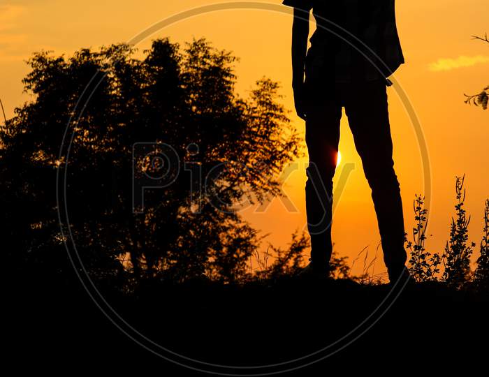 Kheralu, Gujarat - November 19, 2020 : Black silhouette of man, man is looking at the sunrise and feel that.