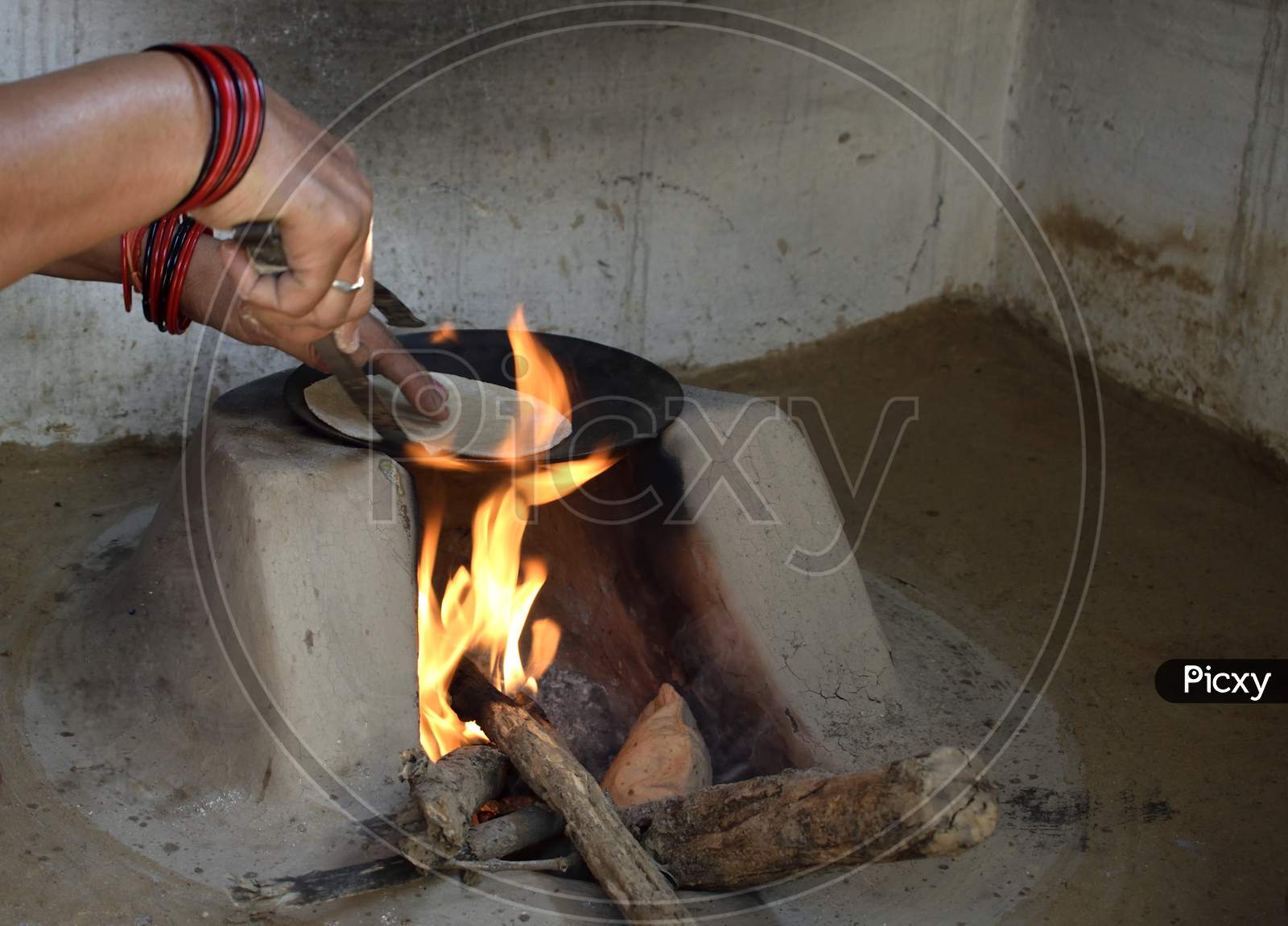 Woman Preparing Chapati In Traditional Way On A Wood Fired Oven