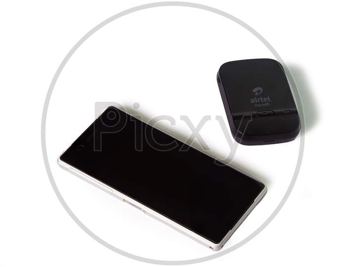 Thrissur, Kerala, India - 12-24-2020: Airtel 4G Hotspot Device And A Smartphone In A White Background