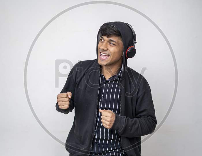 Young Handsome Man Listening Music With Headphones Wearing A Black Hoodie Smiling Face Standing On White Background