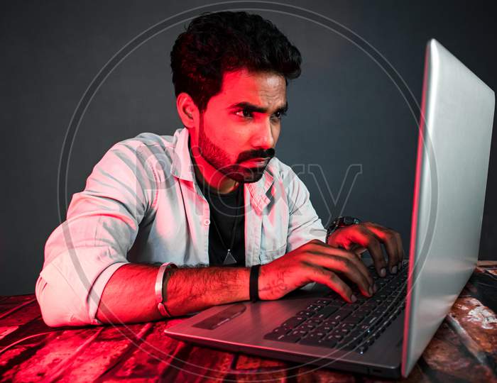 Hacker and Security Expert Working Seriously at Laptop