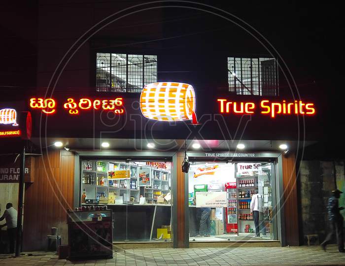 A Night view of a Liquor True spirits shop with Colorful neon advertisement lights which were reopened recently after closure due to Covid 19 Pandemic in Mysuru,India.