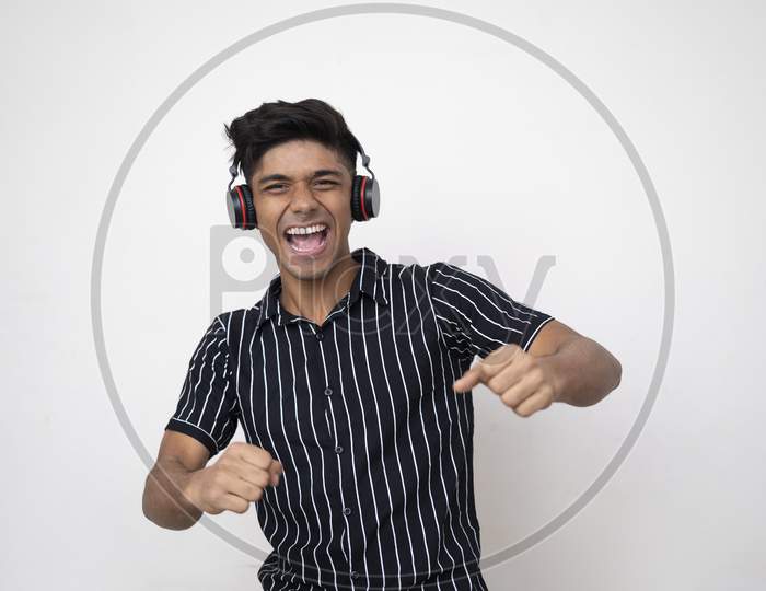 Happy Indian Handsome Man And Headphone Listening To Music On White Background. Happy Concept.