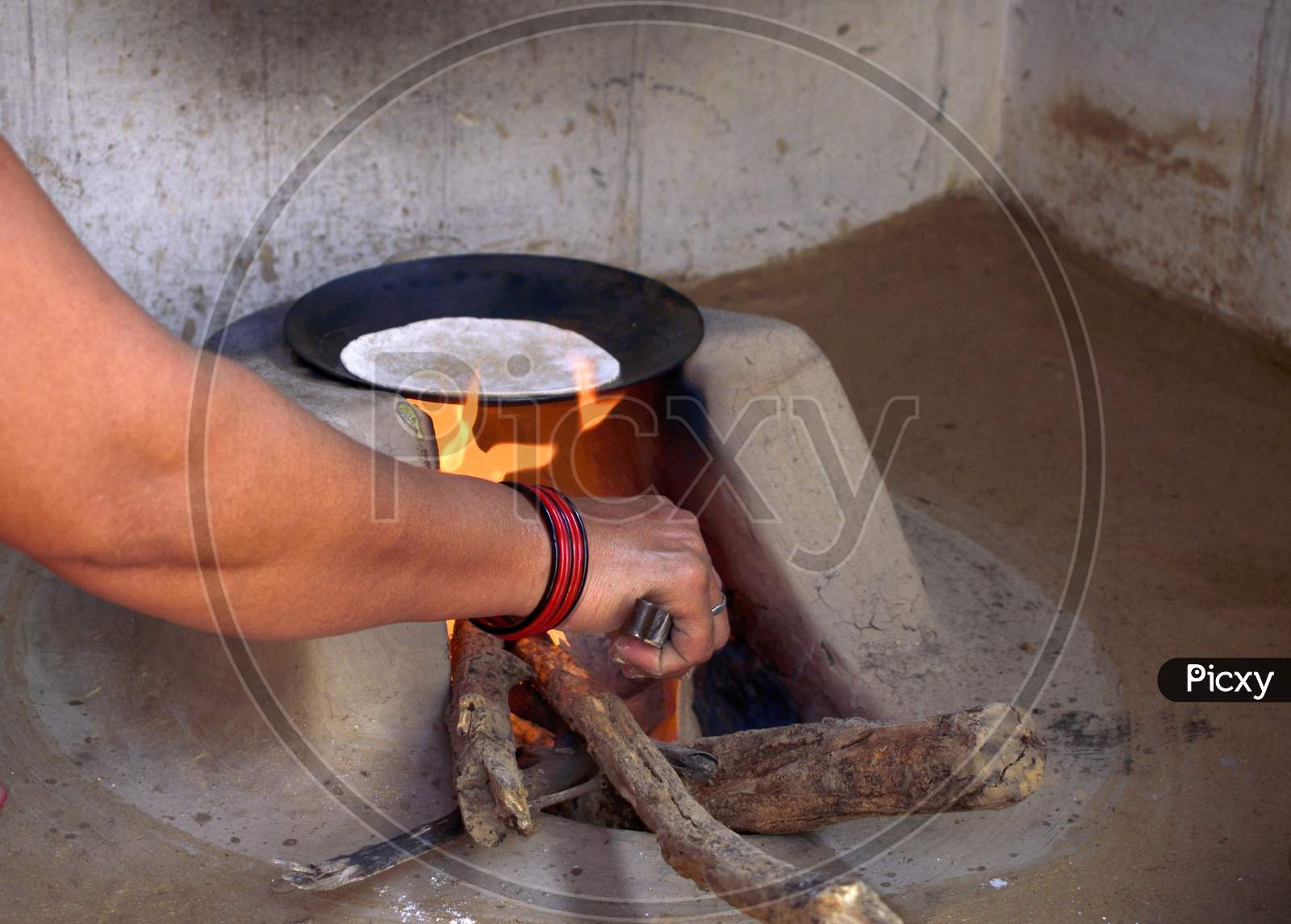 Woman Preparing Chapati In Traditional Way On A Wood Fired Oven