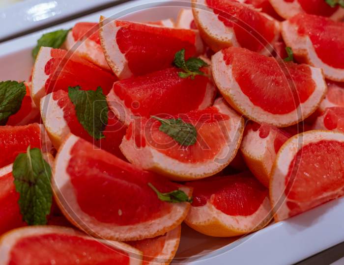 Red Oranged Slices Topped With Mint Leaves
