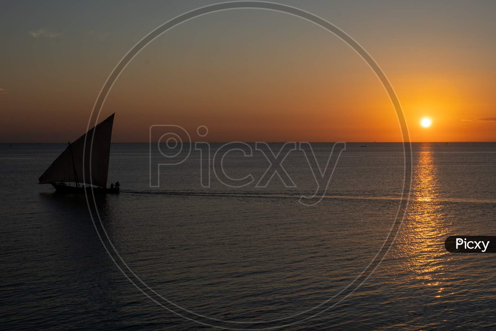 Wooden Sailboat On The Clear Water Of Zanzibar Island During Sunset