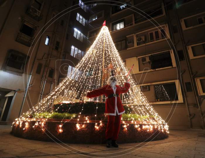 A woman dressed as Santa Claus poses for a picture at a residential area on Christmas eve in Mumbai, India, December 24, 2020.
