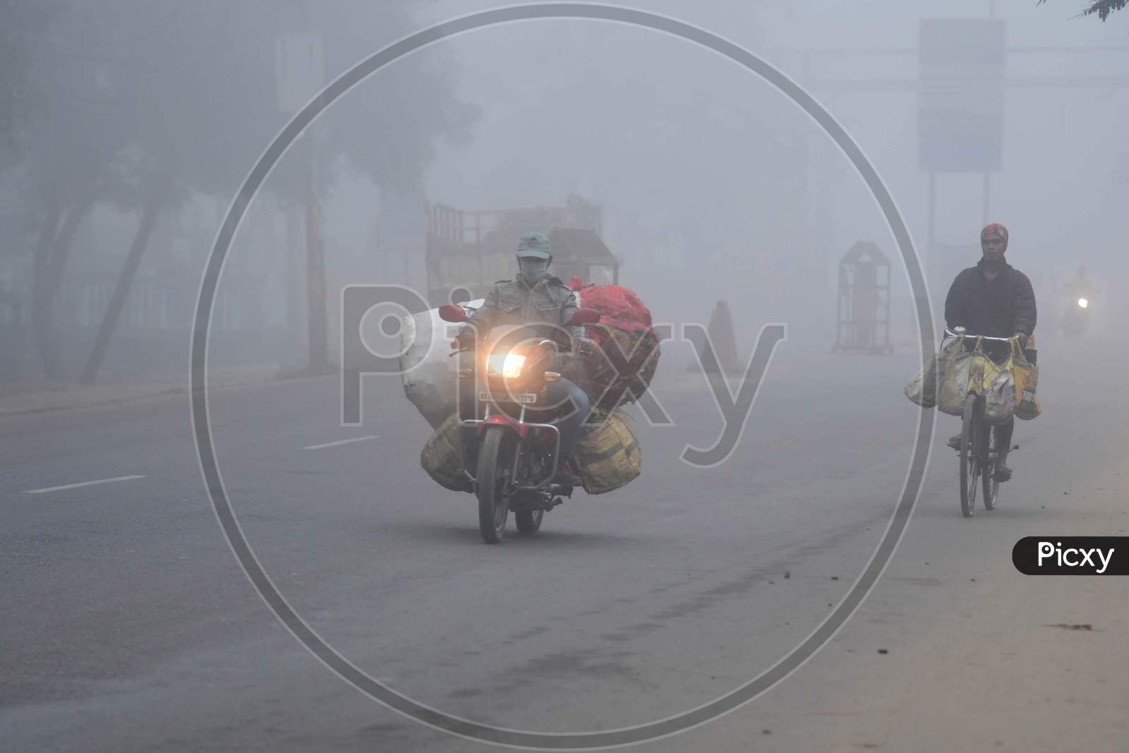 A motorcyclist drives  on a foggy and cold morning in  Assam on Dec 28,2020
