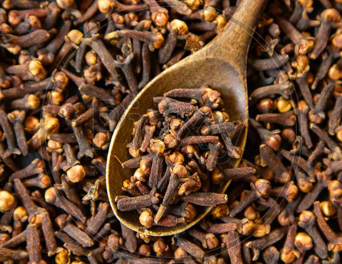 Top View Dried Cloves With A Wooden Spoon