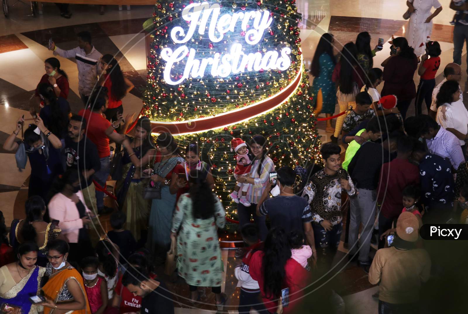 People take pictures with the christmas decoration, as they celebrate Christmas, inside a mall,  in Mumbai, India, December, 2020.