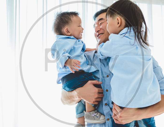 Happy Father Carrying Two Children In Bedroom At Home. Asian Family Living And Having Facial Expression Togetherness. Leisure Time. People Lifestyle Health. Quarantine Covid-19 Coranavirus Theme