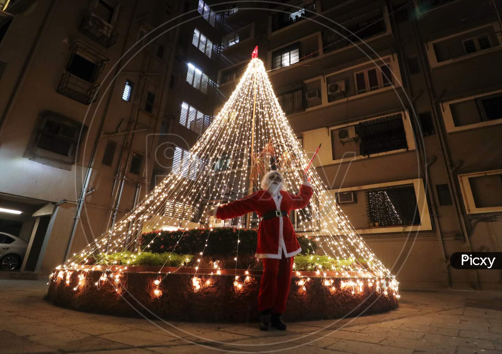 A woman dressed as Santa Claus poses for a picture at a residential area on Christmas eve in Mumbai, India, December 24, 2020.