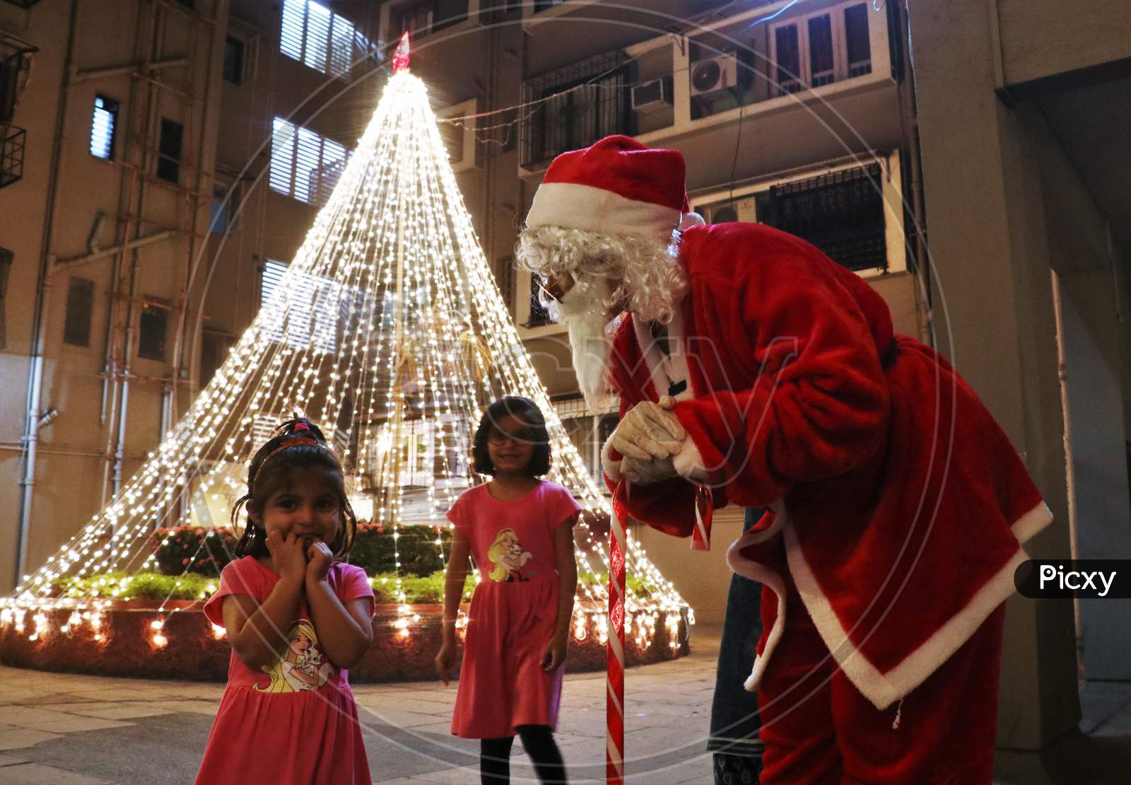 A woman dressed as Santa Claus interacts with kids at a residential area on Christmas eve in Mumbai, India, December 24, 2020.