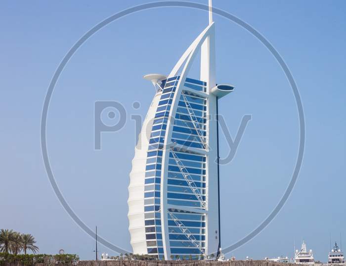 Burj Al-Arab In The Daytime Against The Background Of The Sea And Blue Sky