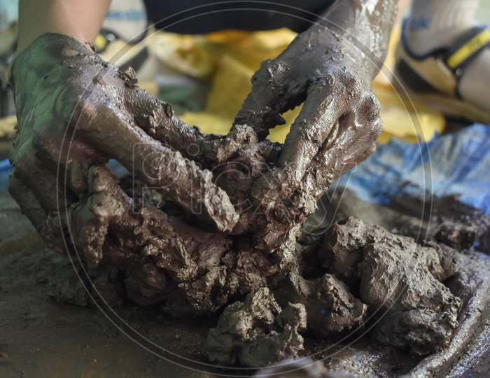 Potter's hand with clay during clay work