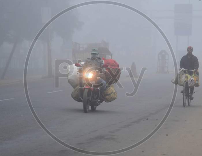 A motorcyclist drives  on a foggy and cold morning in  Assam on Dec 28,2020