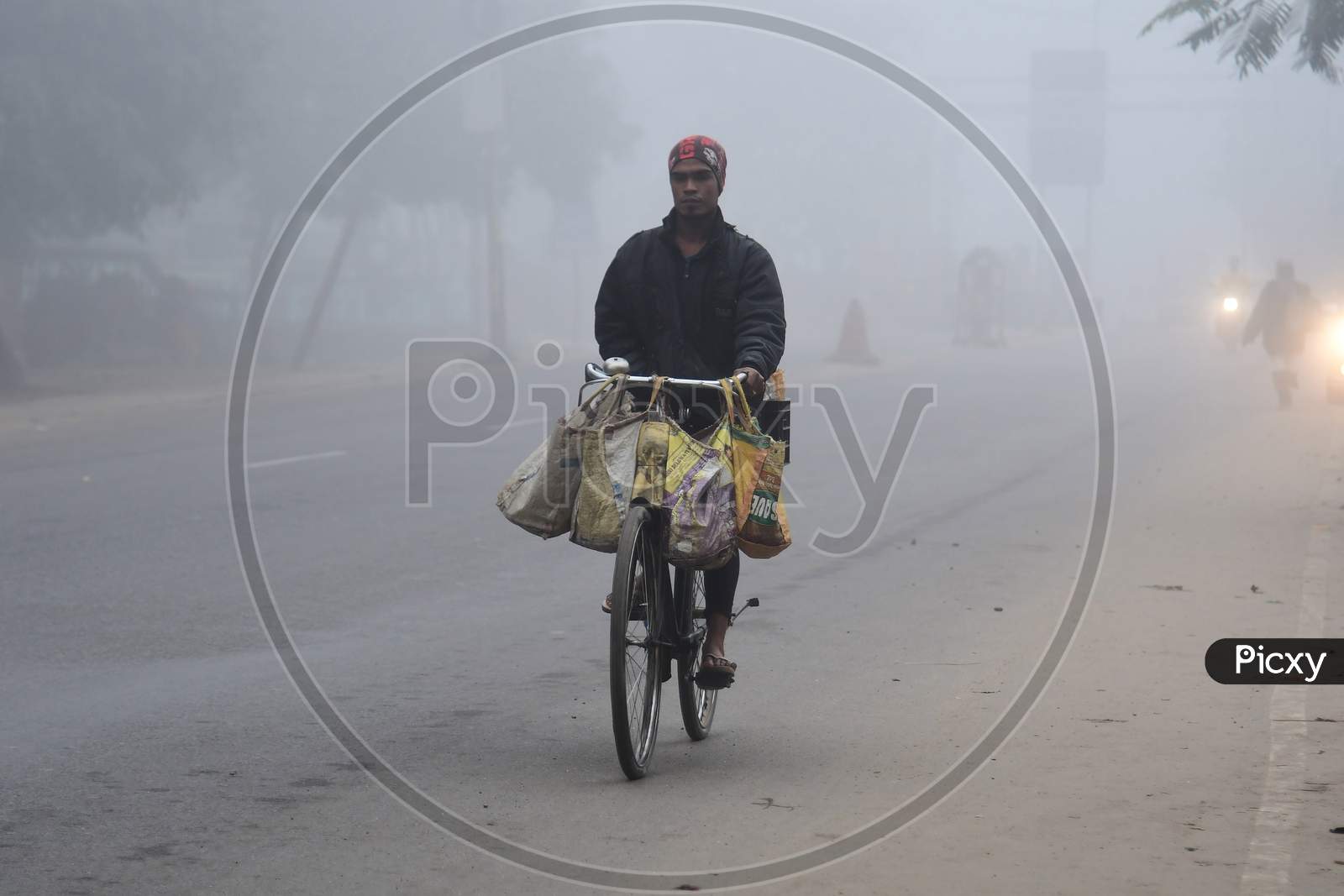 A man ride his bicycle  on a foggy and cold morning in Assam on Dec 28,2020.