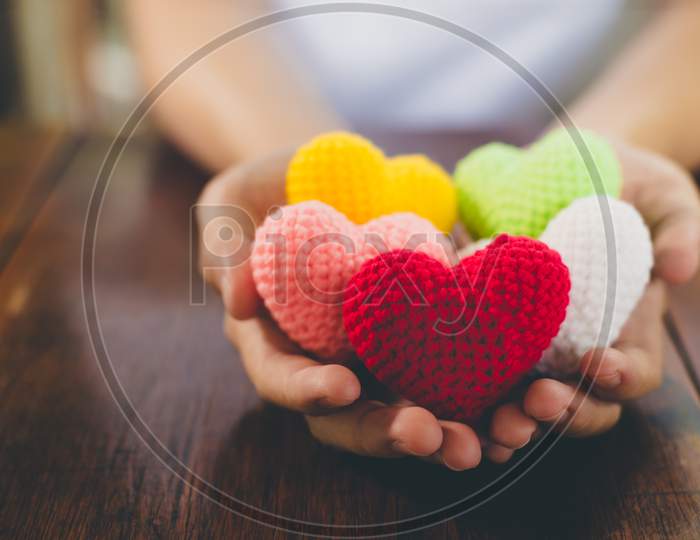 Mixed Colors Yarn Heart On Giving Hands. Close Up Of Colorful Handmade. Healthy Heart Donation And Health Care Concept. Valentine Romance Love Forever Theme
