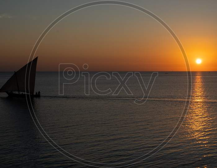 Wooden Sailboat On The Clear Water Of Zanzibar Island During Sunset