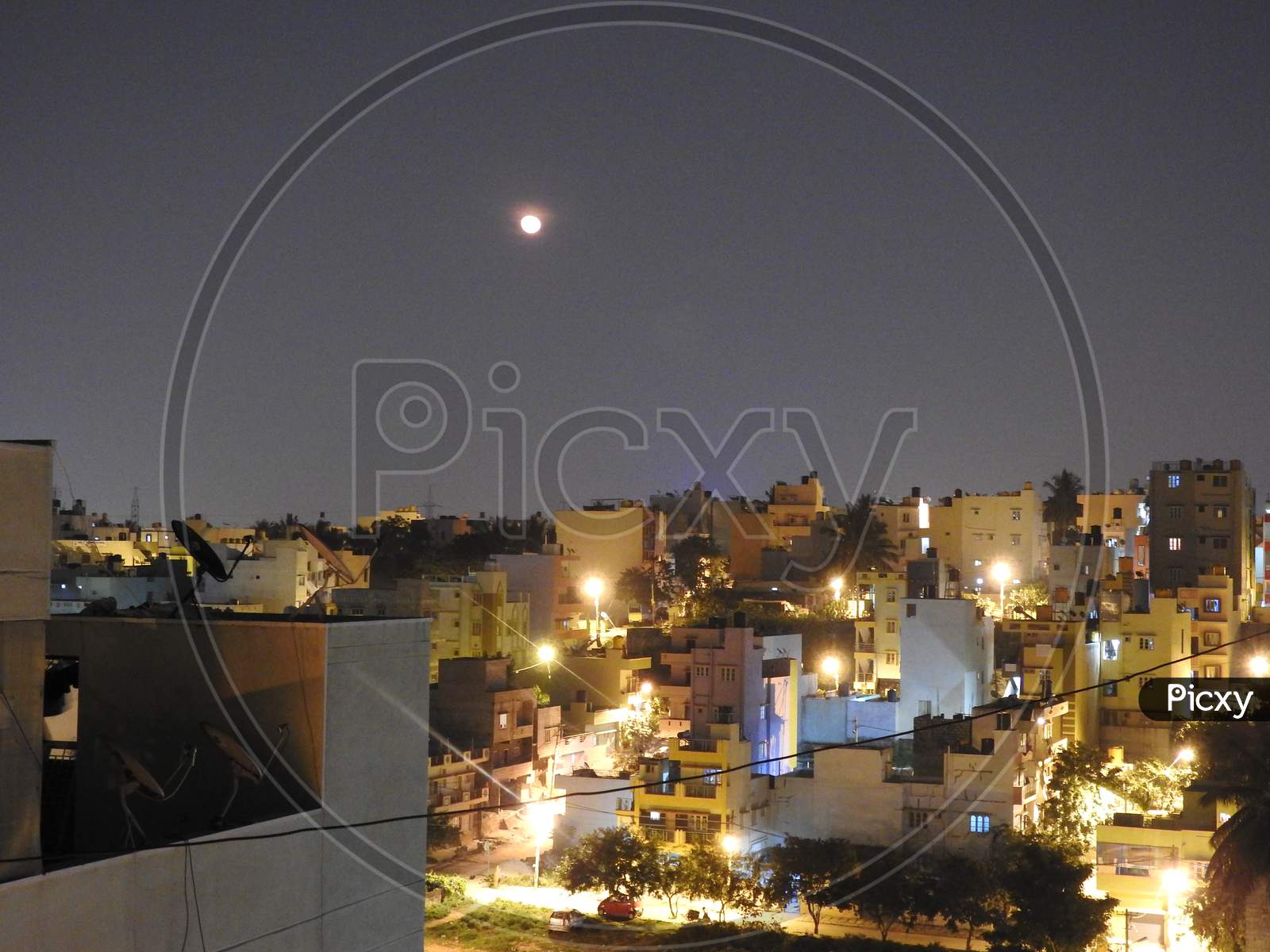 Bangalore Cityscape View At Night With Full Moon And Building Lights Are Glowing
