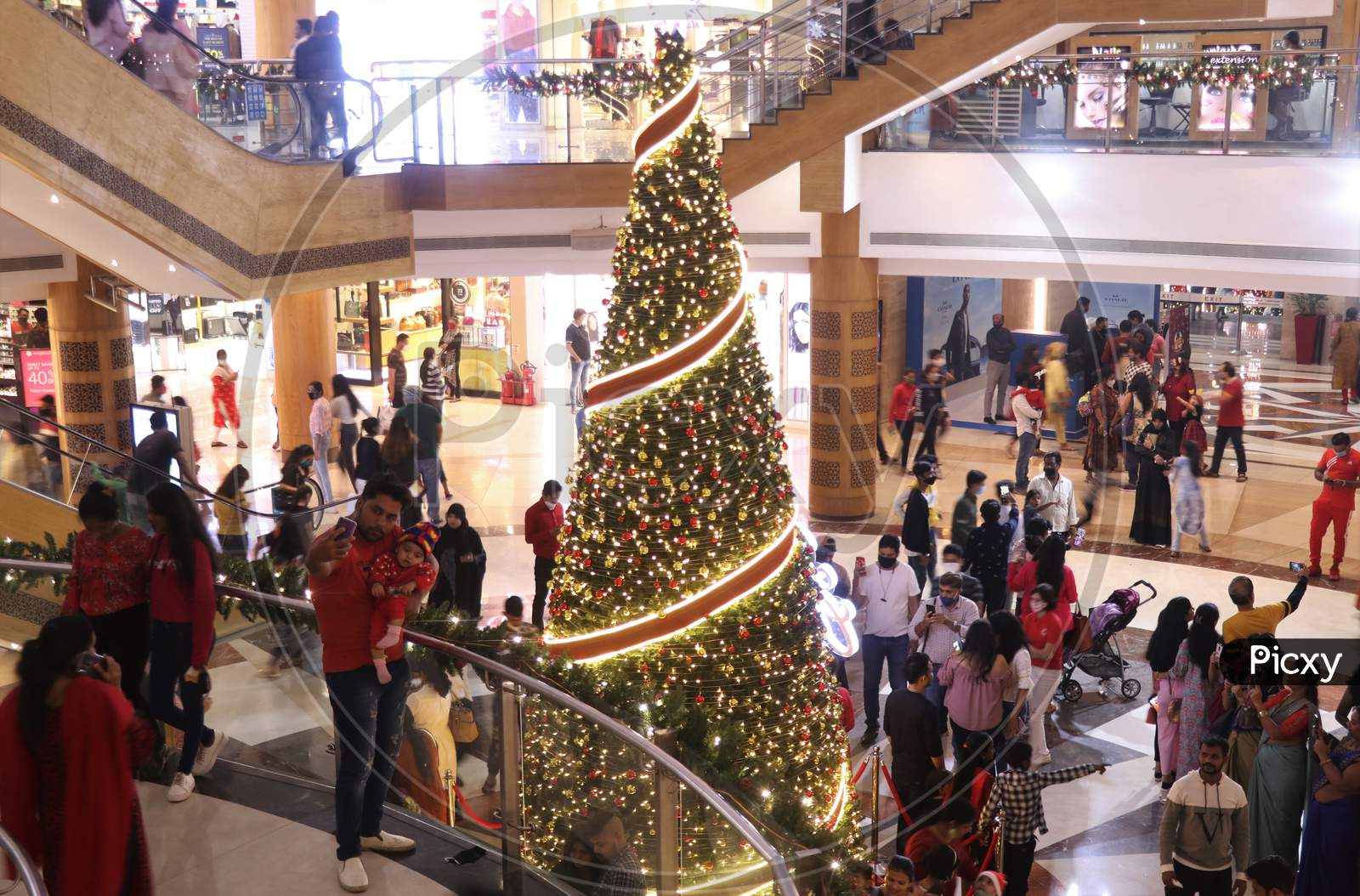 People take pictures with christmas decorations, as they celebrate Christmas, inside a mall,  in Mumbai, India, December, 2020.