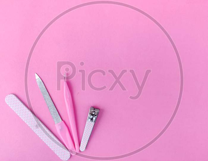 Set Of Pink Color Manicure Tools Isolated On Pink Background. Copy Space
