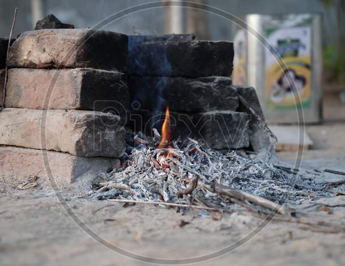 Charcoal Burning In The Clay Stove In The Countryside India. Fire Is Burning In A Compact Brazier, The Embers Smolder.