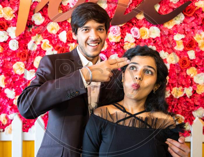 Young Happy Cheerful Indian Couple In Love Have Fun Together, Man Making Shooting Gun Hand Gesture, New Year Or Valentines Day Concept.