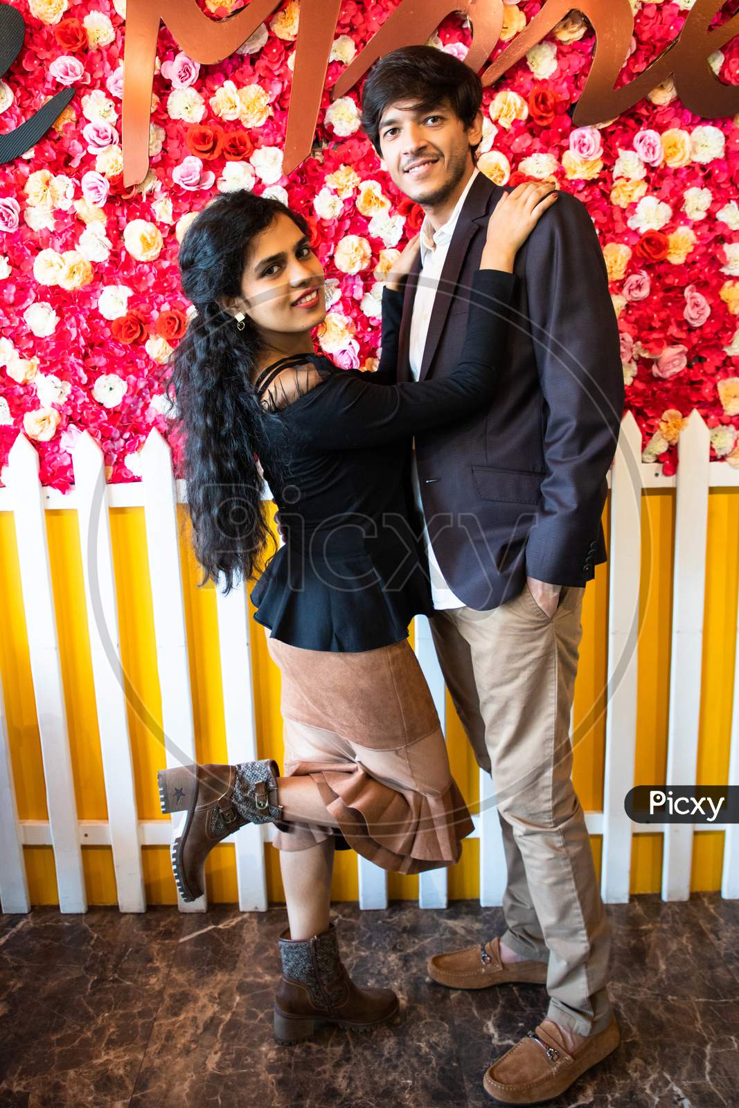 Portrait Of Young Happy Indian Couple In Love Have Against Floral Background, New Year Or Valentines Day.