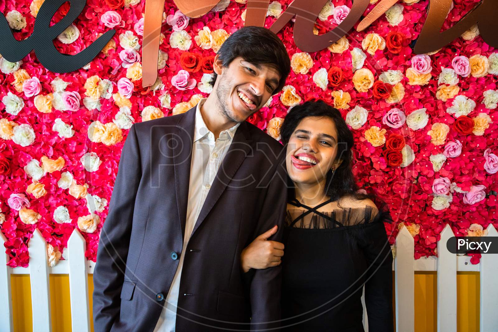 Young Happy Cheerful Indian Couple In Love Have Fun Together Against Floral Background, Boyfriend Girlfriend Relationship, Enjoy Life, New Year Or Valentines Day.