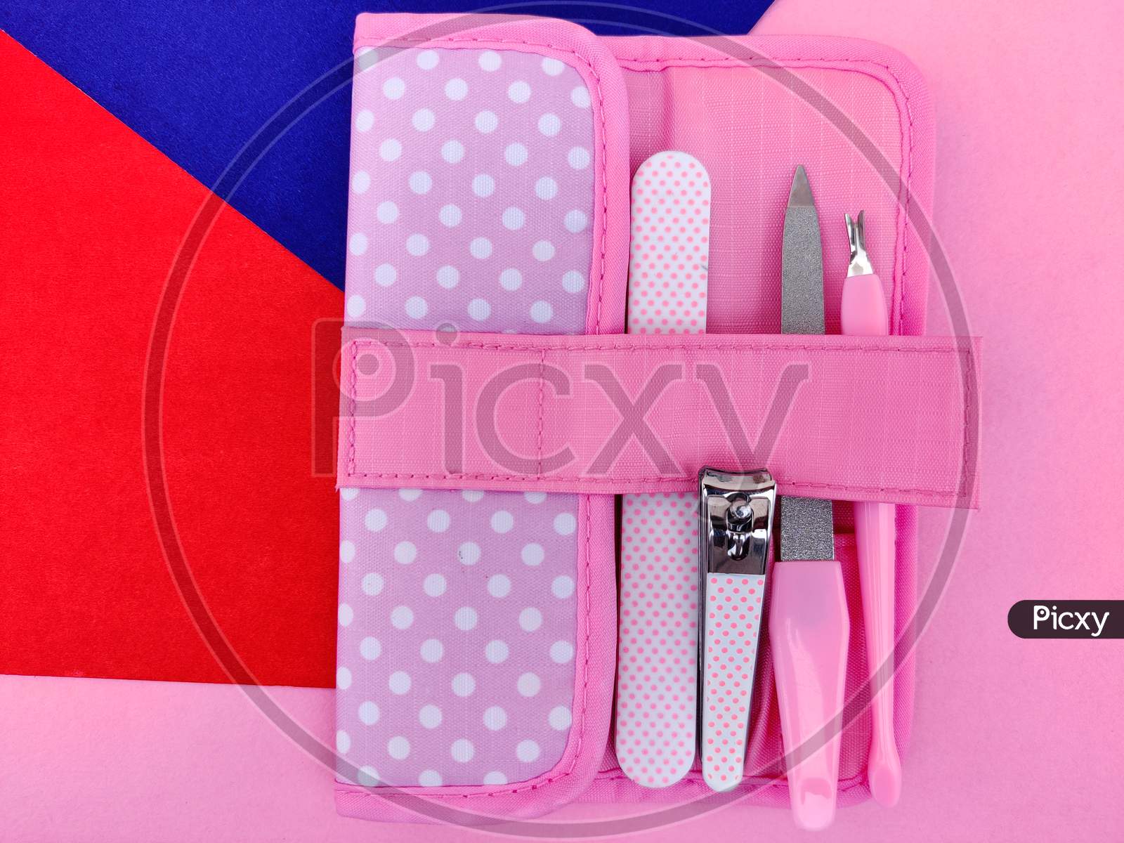 Pink Color Manicure Tools In Pouch Isolated On Pink Background.