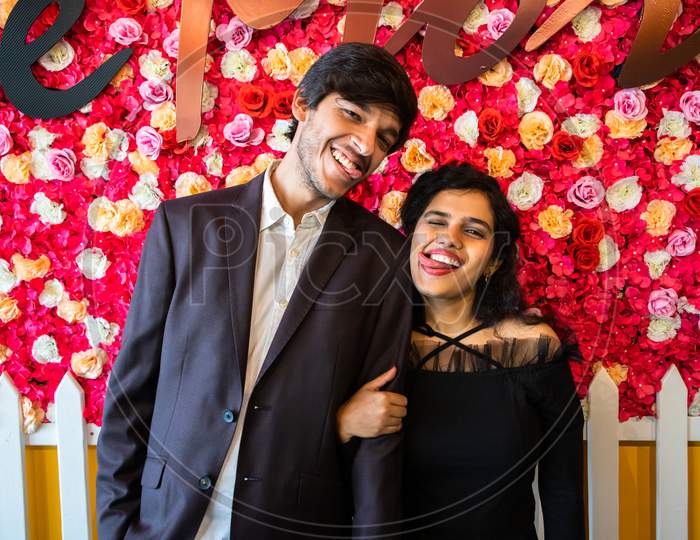 Young Happy Cheerful Indian Couple In Love Have Fun Together Against Floral Background, Boyfriend Girlfriend Relationship, Enjoy Life, New Year Or Valentines Day.