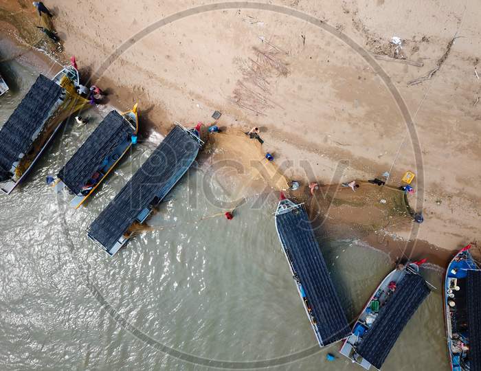Aerial View Fisherman Clear The Small Fish Trap At The Net