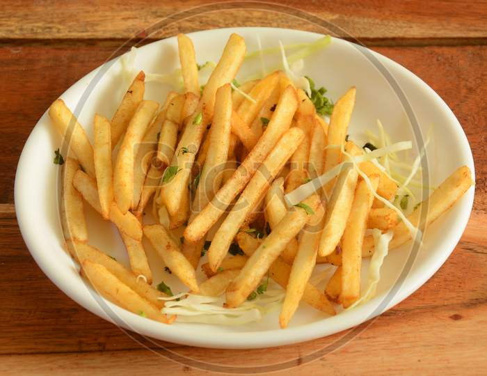Golden Fried French Fries Served In A Plate Over A Rustic Wooden Background, Selective Focus