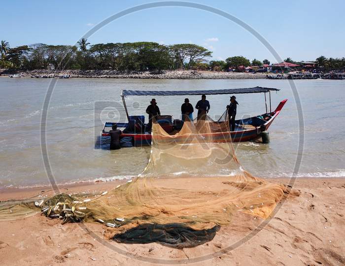 Fishermen Clean The Net At Coastal