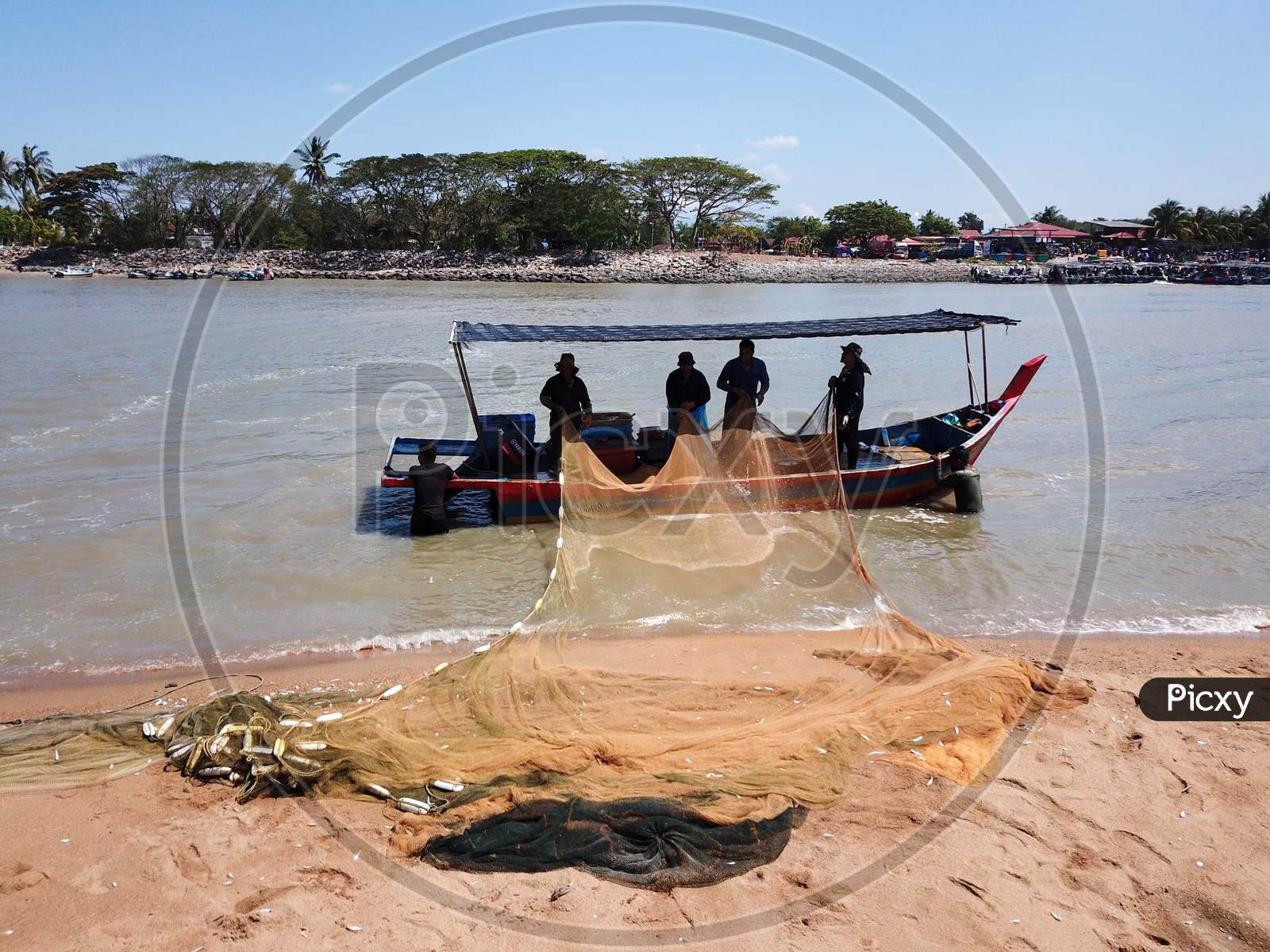 Fishermen Clean The Net At Coastal