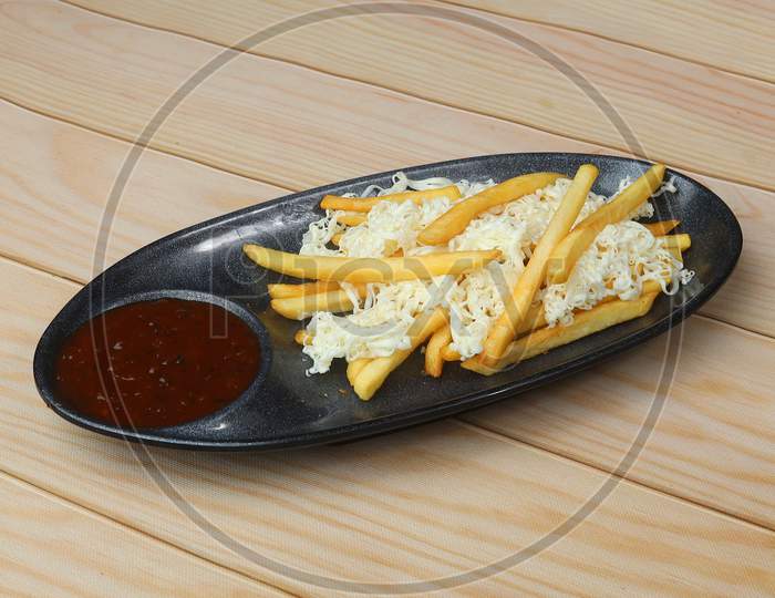 French Fries Topped With Cheese, Served In A Plate Over A Rustic Wooden Background, Selective Focus
