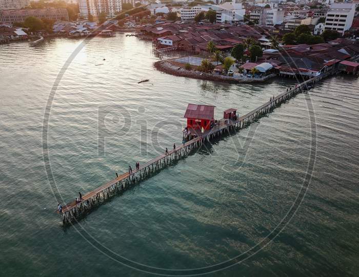 Aerial View Tan Jetty With Red Temple During Sunset